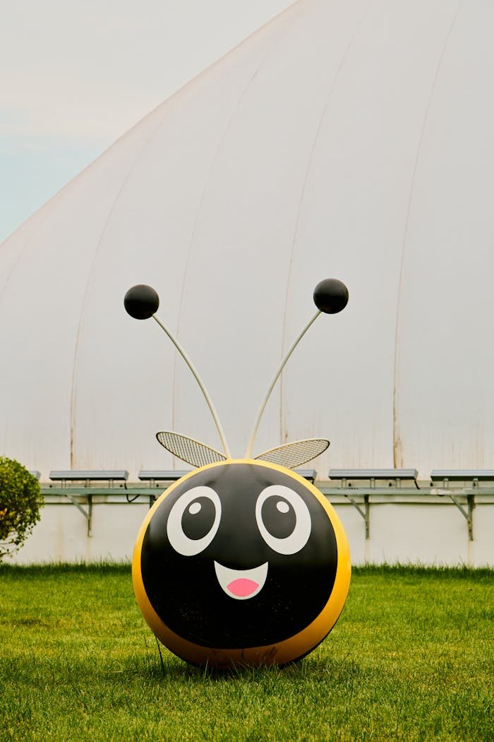 cheerful cartoon bee sculpture in green park 34165759