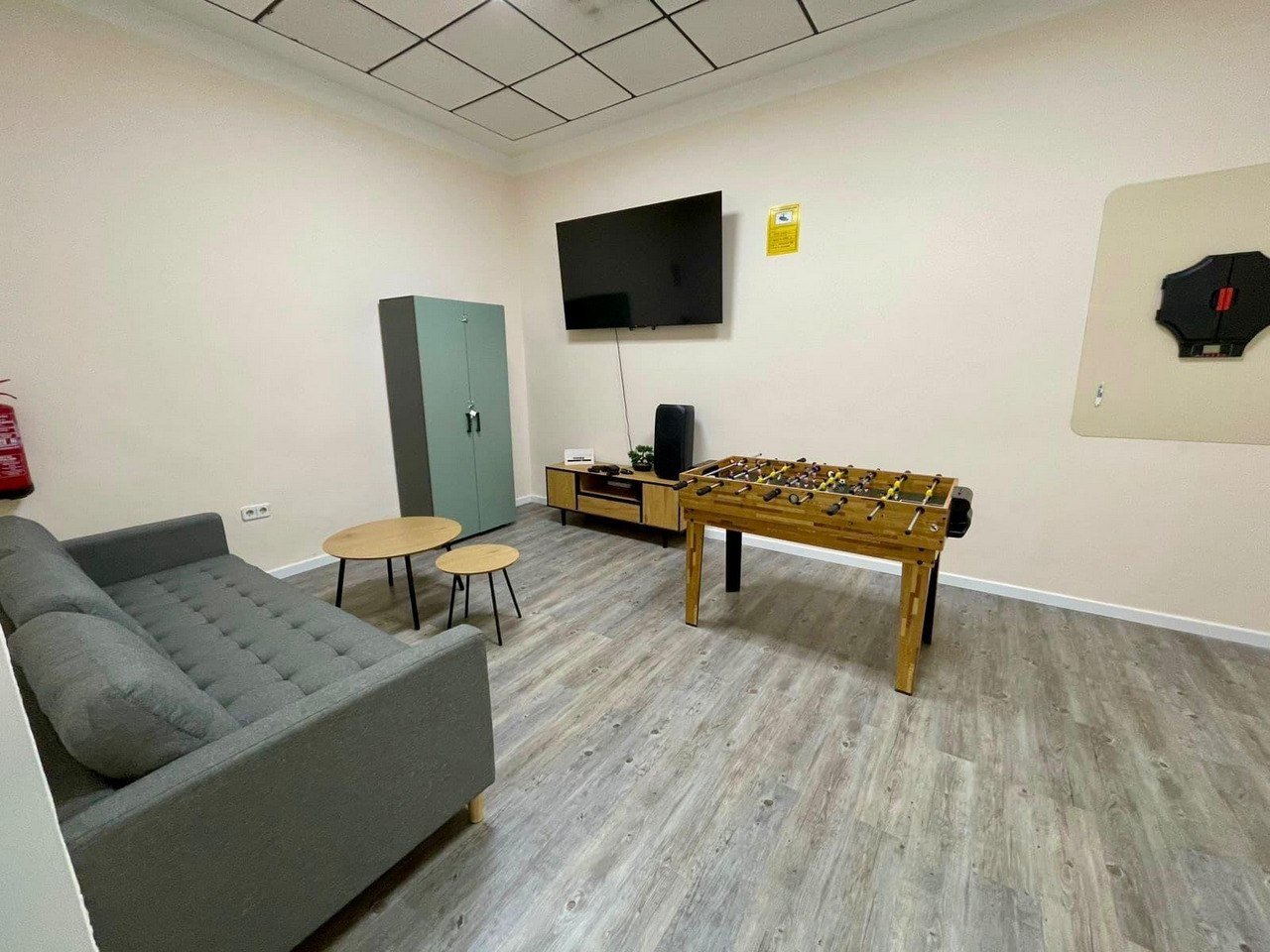 Zona de descanso y ocio con sofá, futbolín y televisión para completar la experiencia.
