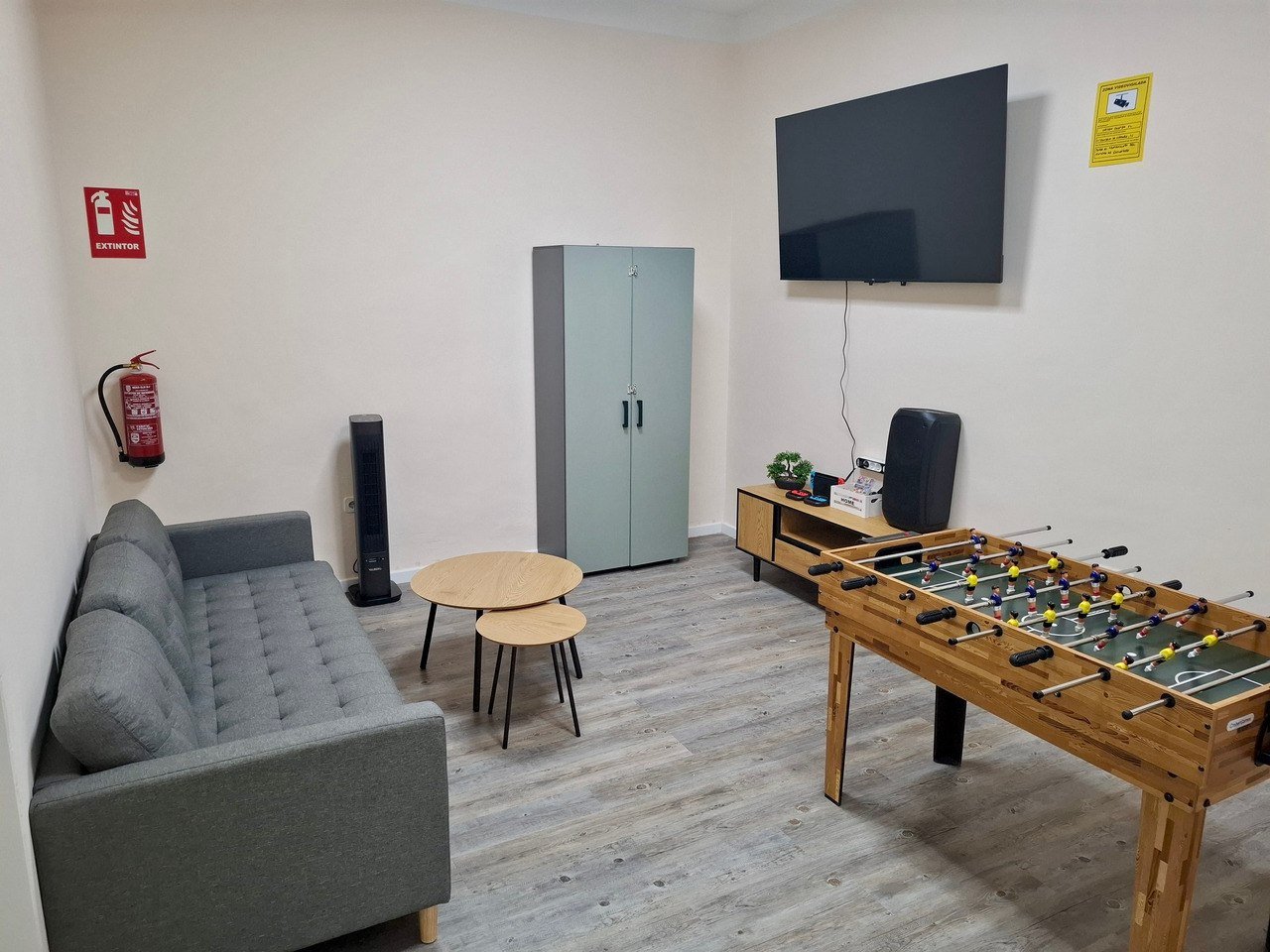 Zona de sofá, futbolín y televisión en Sanferland